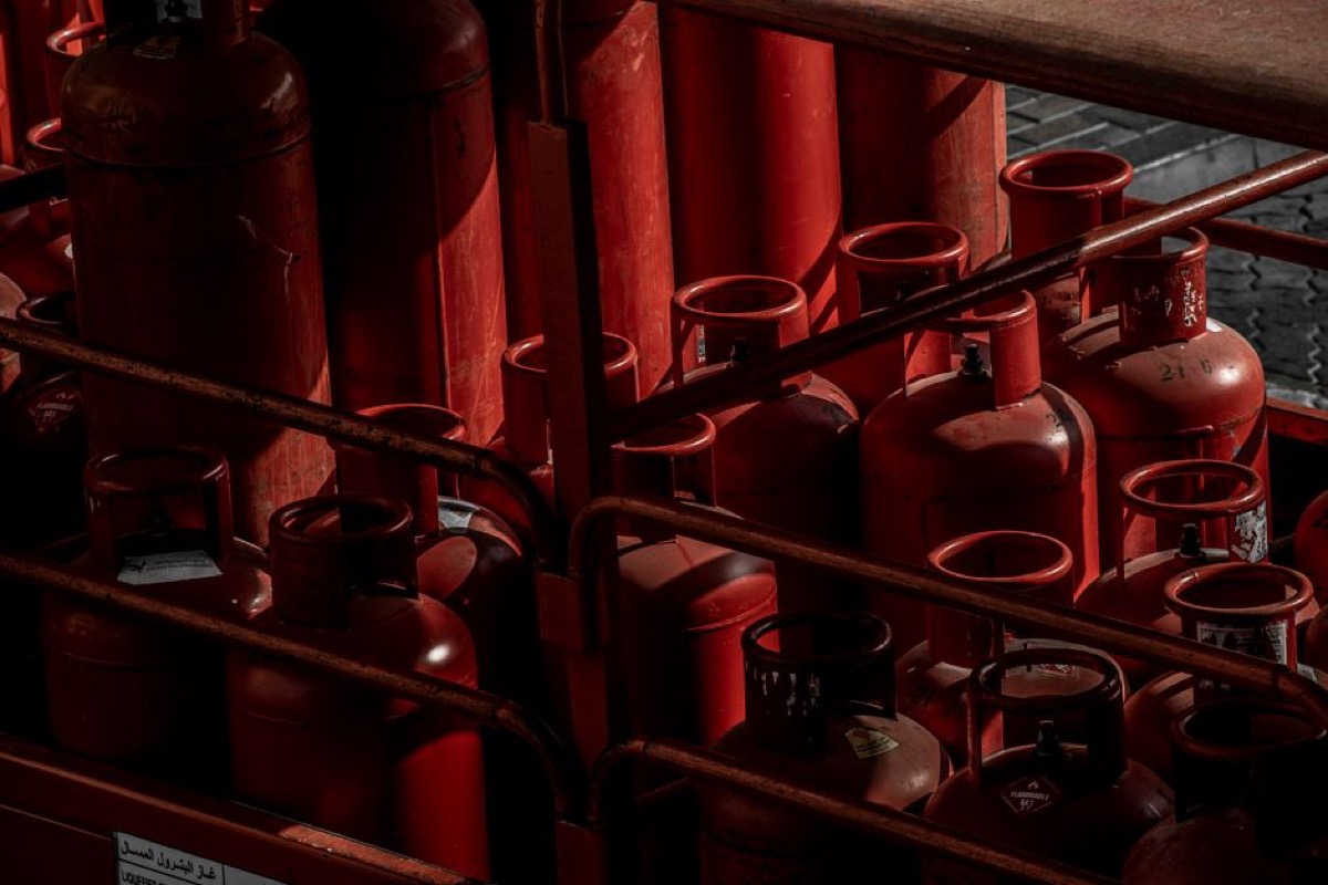 Red propane gas cylinders stored outdoors, representing the LP propane fuel option for tri-fuel portable generators