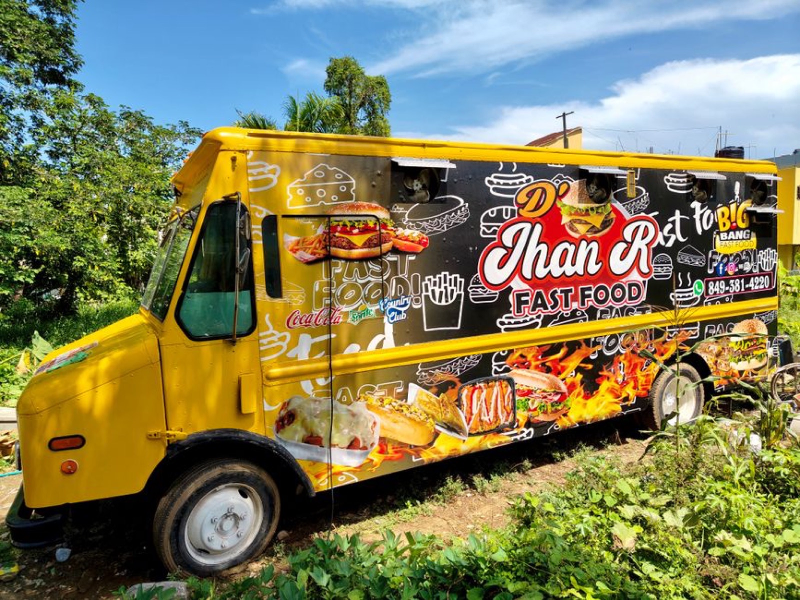 Colorful food truck parked outdoors serving customers at a busy street food event
