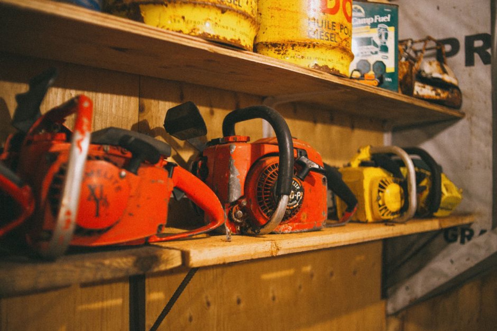 Small engine outdoor power equipment storage shelf with fuel cans and tools