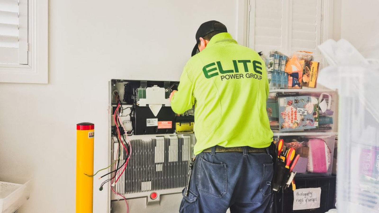 Technician installing standby generator transfer switch and electrical connections for home backup power system