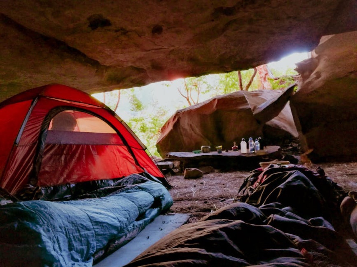 Camping gear and portable generator at wilderness tent site