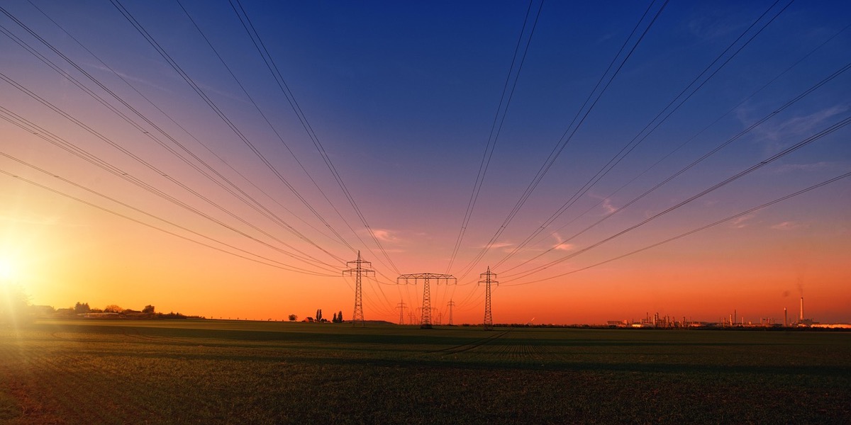 Power transmission lines at sunset representing grid infrastructure