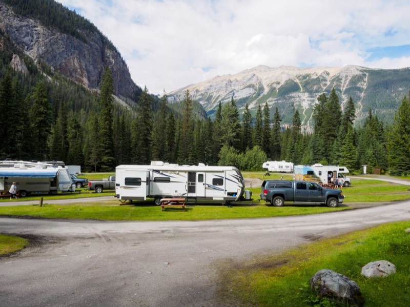 Travel trailer and RVs in scenic mountain campground landscape for extended boondocking