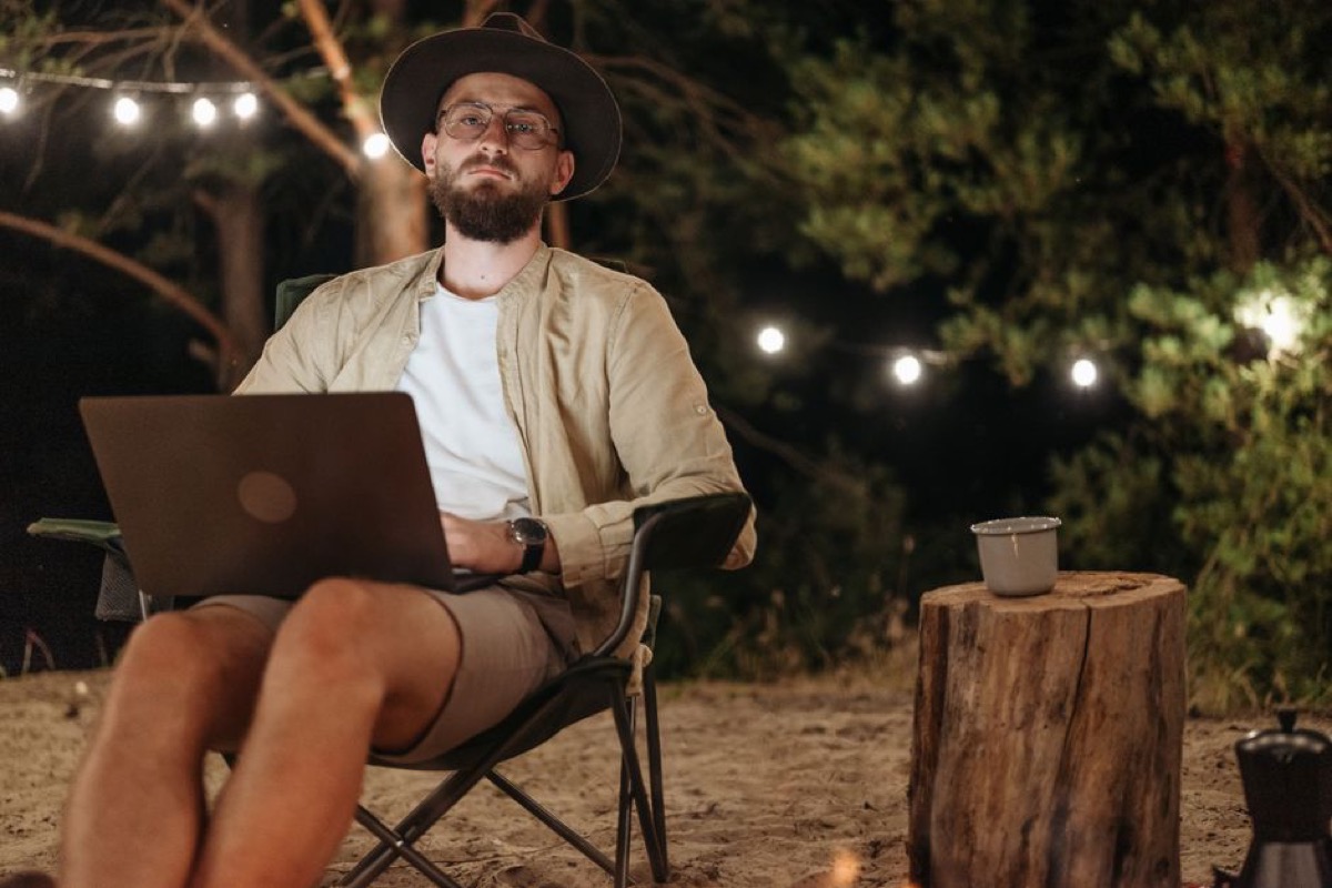 Person using laptop outdoors powered by portable generator
